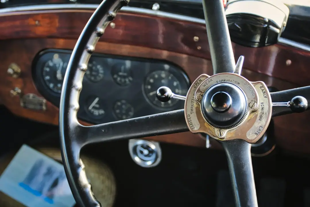 Vintage steering wheel in front of a wooden dashboard